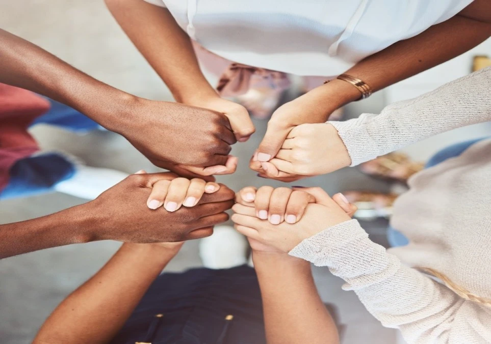 Multicultural group of people holding hands in circle